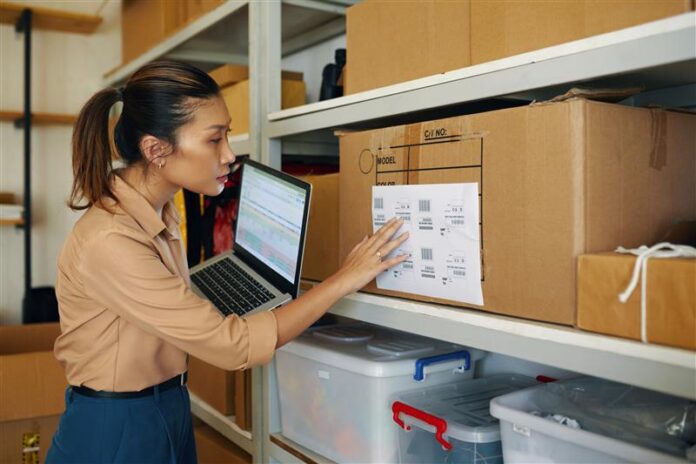 worker-checking-codes-on-box-with-online-informati-2025-01-31-05-02-22-utc